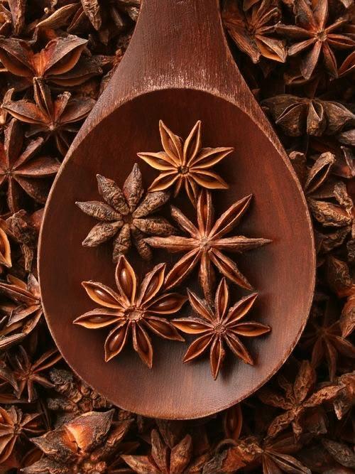 Dried star anise arranged in a wooden spoon